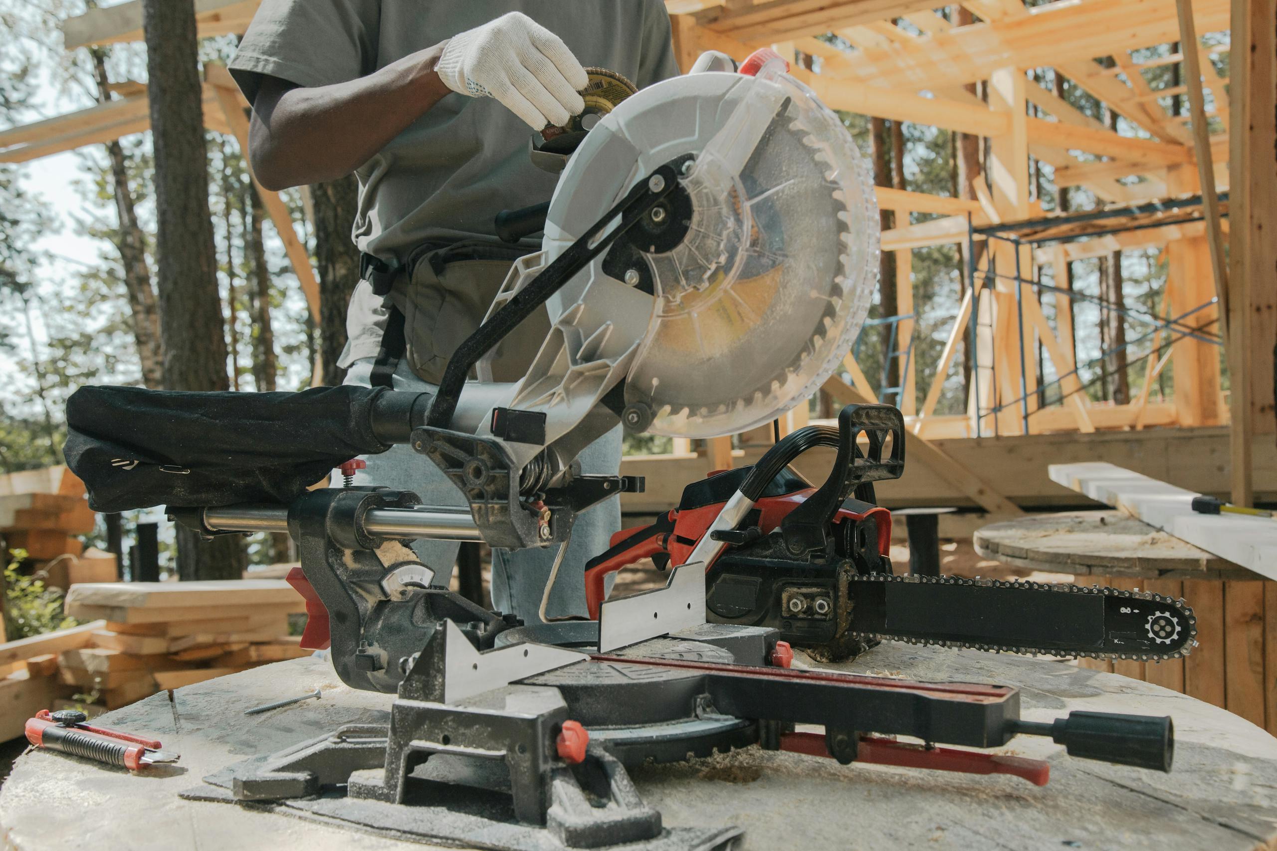 Close-up of a worker using a circular saw amidst forest construction. Manual craftsmanship at its best.